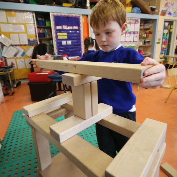 Child making a wooden structure in class